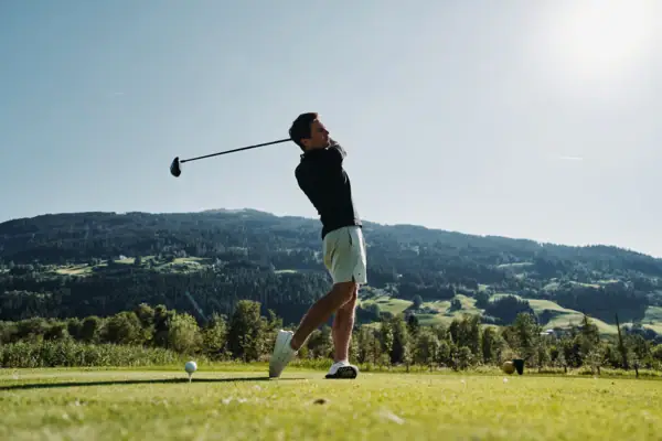 Golfplatz Bad Gastein Ein Mann schwingt einen Golfschläger auf einem Golfplatz.